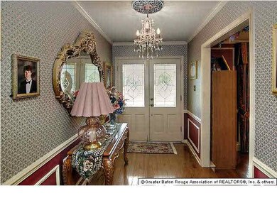 Foyer with wood floors and crown molding