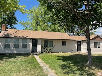 Ranch-style home with a chimney, a front yard, board and batten siding, and a shingled roof