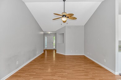 Unfurnished living room featuring light wood-style flooring, baseboards, a ceiling fan, and lofted ceiling