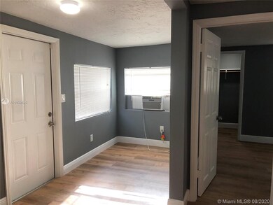 To the left is the door to the outside patio, the living area is in the middle and the entrance to the bedroom to the right.  You'll note there's another wall AC in the living area.
