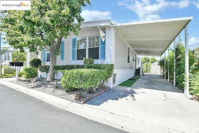 View of side of property with a storage shed, a carport, and driveway