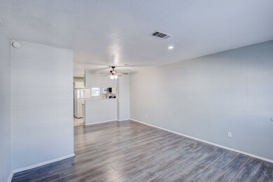 Empty room featuring dark wood-style flooring, a ceiling fan, and recessed lighting