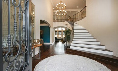 Incredibly entry showcasing the gorgeous CUSTOM iron work in the spanish style as well as a fabulous custom iron chandelier. The wrought iron railings were also done on the second (back) staircase.