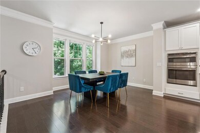 Dining area with a chandelier, ornamental molding, and dark wood-style flooring