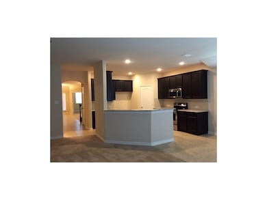Kitchen with arched walkways, stainless steel appliances, dark cabinetry, recessed lighting, and light stone countertops