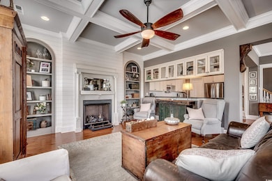 Living room featuring coffered ceiling, a fireplace, and beam ceiling
