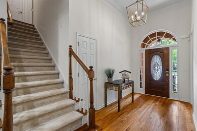 Warm hardwood flooring  and NEW stylish lighting invite guests inside (side stairs out of the way for upper level access) door to coat closet
