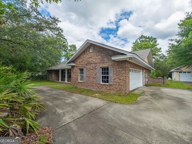 Side view of the home showcasing the brick exterior and spacious front yard.