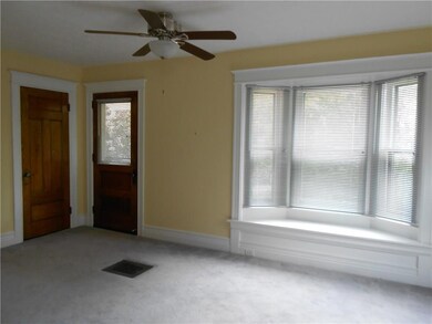 The upper unit living room has a window seat, coat