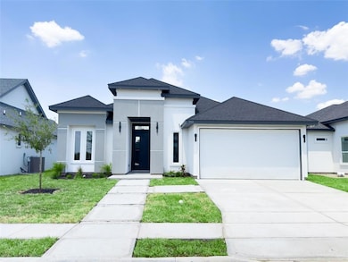 Prairie-style house with a front yard, a garage, and central air condition unit
