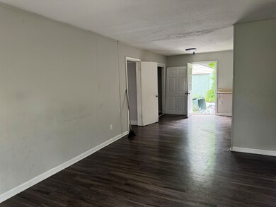 Empty room featuring a textured ceiling and dark h