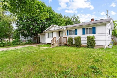 View of front of house featuring driveway, a chimney, and a garage