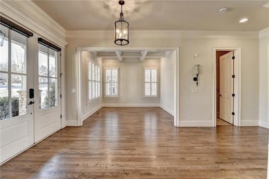 Entryway featuring ornamental molding, wood finish