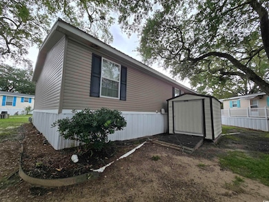View of side of property featuring cooling unit and a storage shed