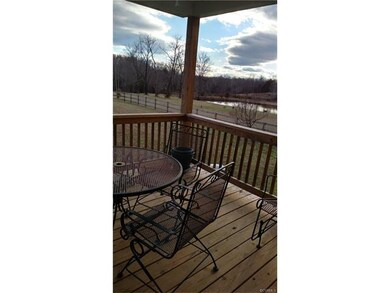Covered rear porch with ceiling fan and lovely pon