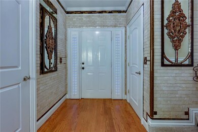 Foyer with ornamental molding, light wood-type flo