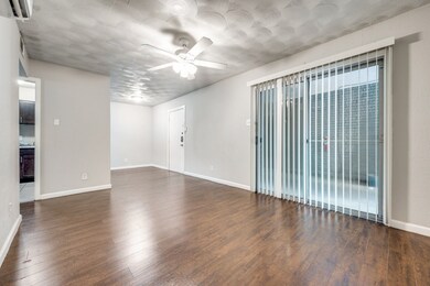 Empty room featuring ceiling fan, dark wood-type flooring, and a wall mounted air conditioner