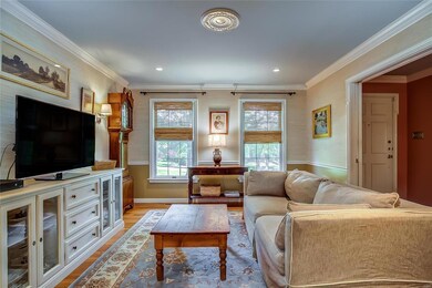 The owners decided to swap out the dining and living room. So, once a good-sized dining room, now a comfy den. Beautifully tailored with grass cloth walls, pretty millwork and a pocket door for privacy from the foyer.