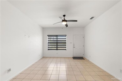 Empty room featuring ceiling fan and baseboards