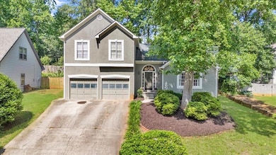 View of front facade with stucco siding, driveway, and a garage