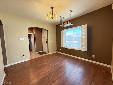Empty room featuring arched walkways, wood finishe