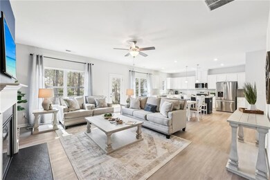 Living room featuring a ceiling fan, light wood-type flooring, recessed lighting, and a fireplace with flush hearth