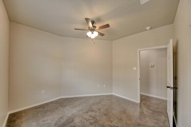 Empty room featuring ceiling fan and baseboards