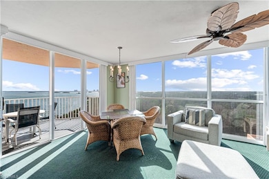 Sunroom / solarium with a water view and ceiling fan Virtually edited image