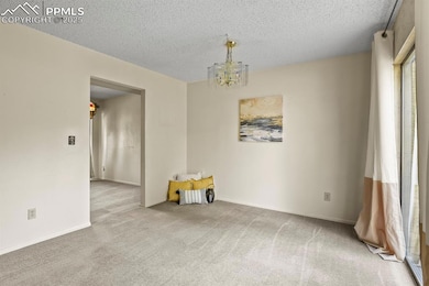 Carpeted spare room with a textured ceiling and a 