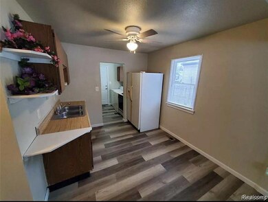 Kitchen with open shelves, light countertops, white refrigerator with ice dispenser, dark wood-type flooring, and a ceiling fan