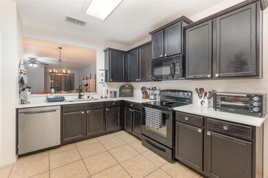 Tiled Kitchen features White Quartz counters and Breakfast Bar, modern Black appliances and Stainless Steel Dishwasher and Bay Window with large Dinette eating space.