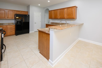 Kitchen featuring black refrigerator with ice disp