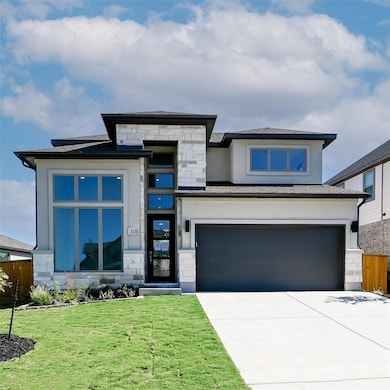 Prairie-style house with stone siding, concrete driveway, and a garage