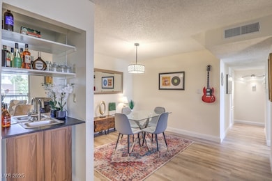 Dining space with visible vents, a textured ceilin