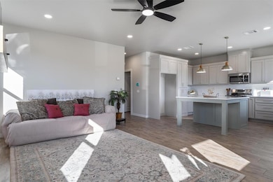 Living room featuring light wood-style flooring, a ceiling fan, and recessed lighting