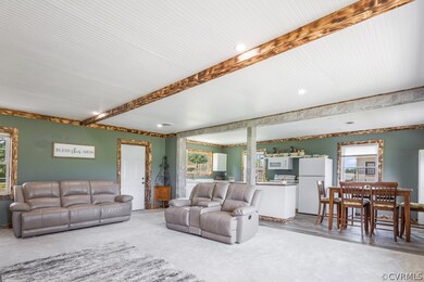 Carpeted living room featuring beamed ceiling and