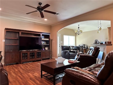Living area featuring arched walkways, a chandelie