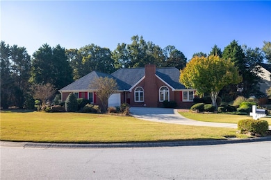 Ranch-style home with driveway, a front lawn, and a chimney