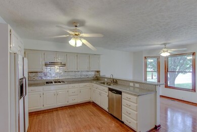 Brightly lit kitchen with convenient eat in space.