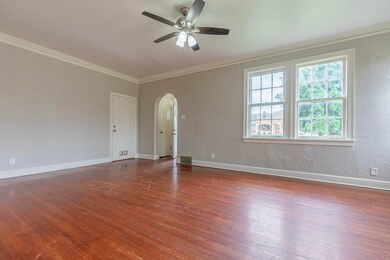 Spare room with ornamental molding, dark wood-type