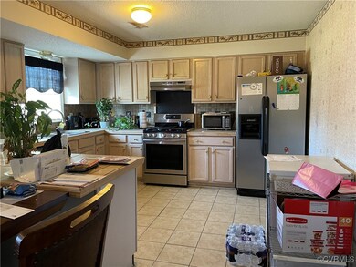 Kitchen with light brown cabinetry, sink, applianc