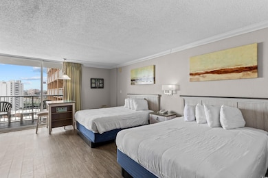Bedroom featuring expansive windows, a textured ceiling, wood finished floors, access to outside, and ornamental molding