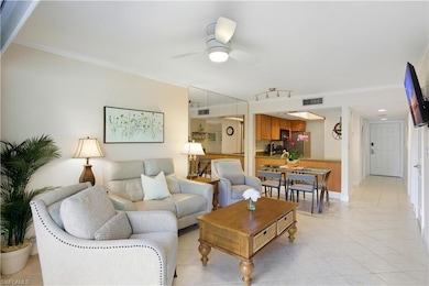 Living area featuring light tile patterned floors, crown molding, and ceiling fan