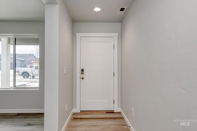 Doorway to outside with wood finished floors and recessed lighting