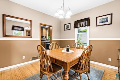Dining space featuring a chandelier, wood finished floors, and baseboards