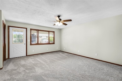 Spare room featuring ceiling fan, carpet, and a textured ceiling