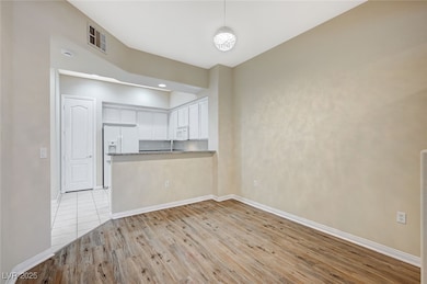 Unfurnished living room featuring light wood-type flooring, baseboards, and visible vents