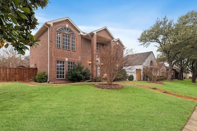 Traditional home with a front yard, fence, and bri