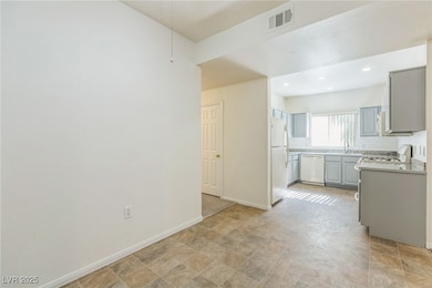 Kitchen featuring white appliances, light countertops, gray cabinetry, stone finish floors, and recessed lighting