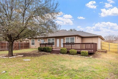 Back of property with a yard, a deck, a fenced bac